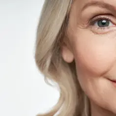 Zbliżenie na twarz kobiety z blond włosami, z widocznymi zmarszczkami wokół oka. Czy zastanawiasz się, jak wyostrzyć wzrok?