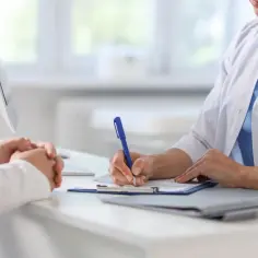 Lekarz notuje informacje o pacjencie, który rozważa ile L4 po laserowej korekcji wzroku.
