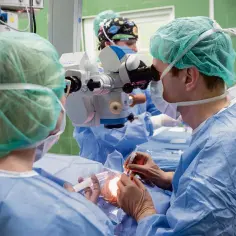 Chirurg wykonuje zabieg okulistyczny, być może w celu leczenia powikłań po operacji jaskry.
