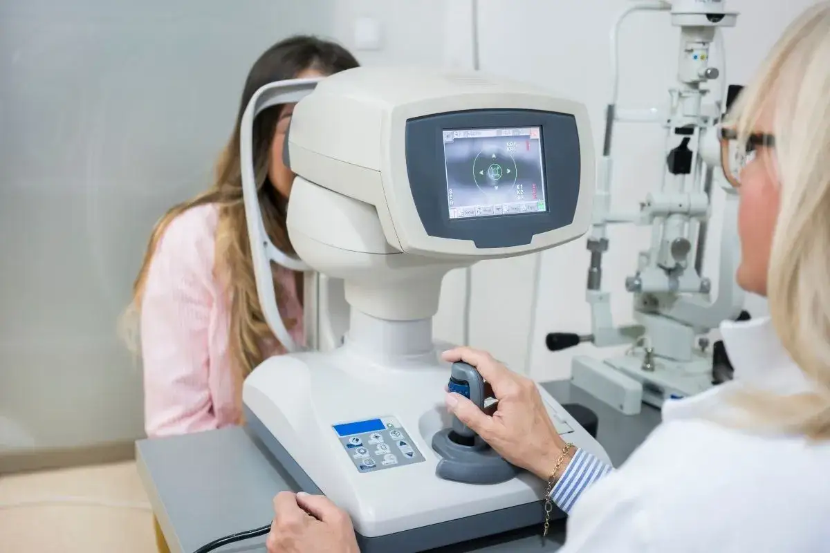 Optometrysta bada wzrok pacjentki za pomocą specjalistycznego sprzętu.