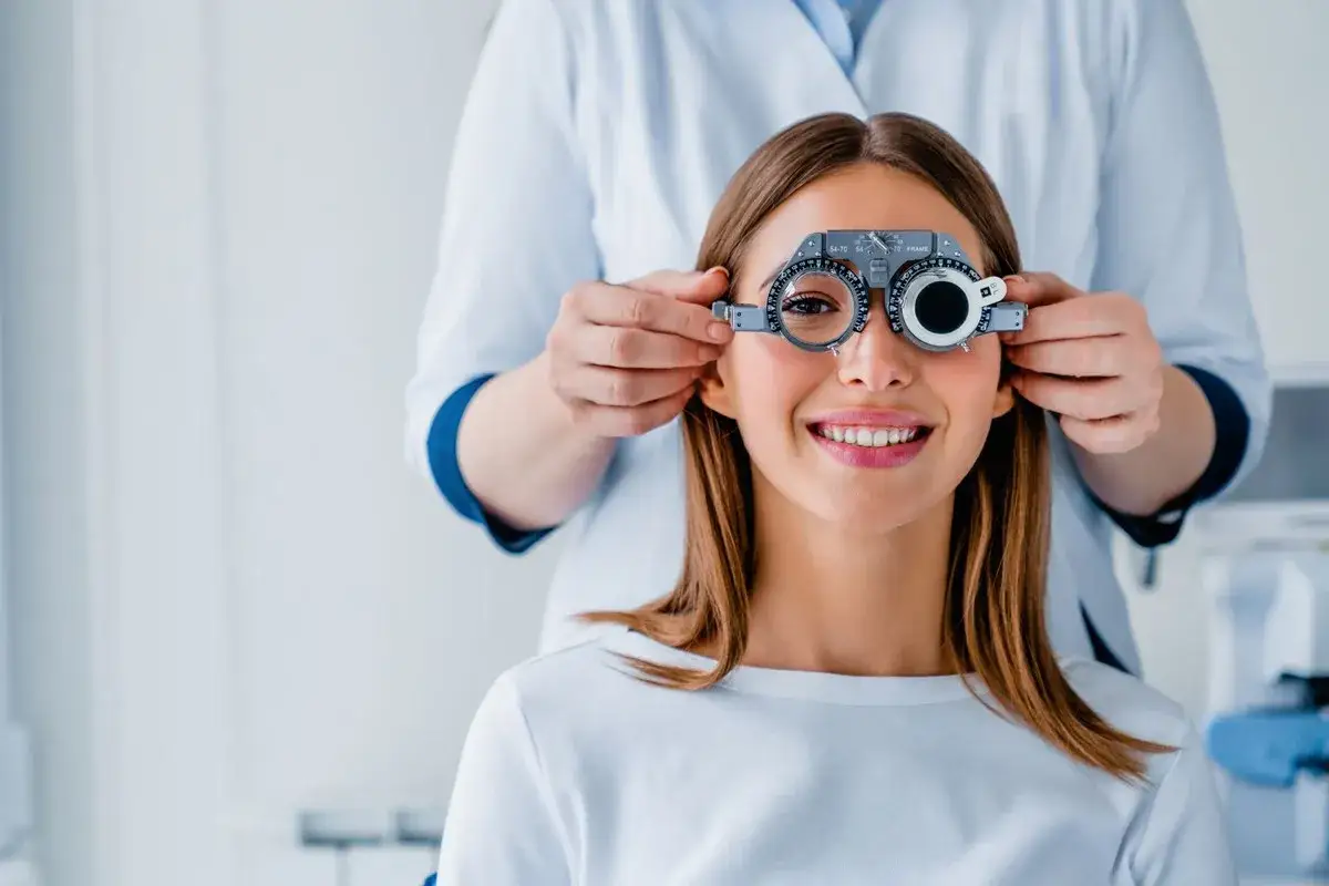 Badanie wzroku u optometrysty. Czy jaskra jest dziedziczna? Młoda kobieta z aparatem do badania wzroku.